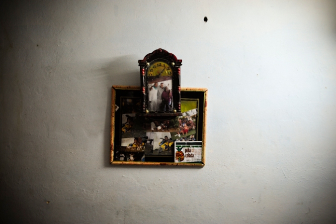 Inside a Cuban home in the village of Carbonera, a frame consisting of the family's momentos hangs in the dining room. Carbonera, Cuba / Photo Jonathan Taillefer.